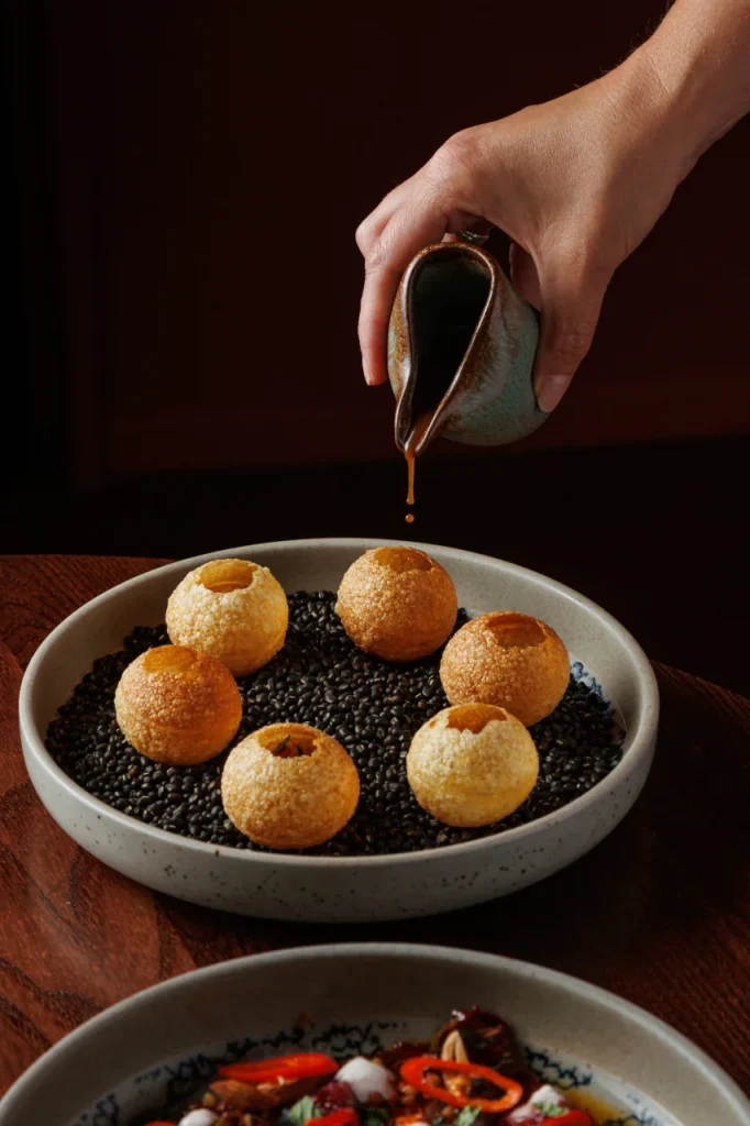 Pani puri being served at Tanvi, an Indian restaurant in St George’s Bay Malta, with tamarind water poured into crispy shells.